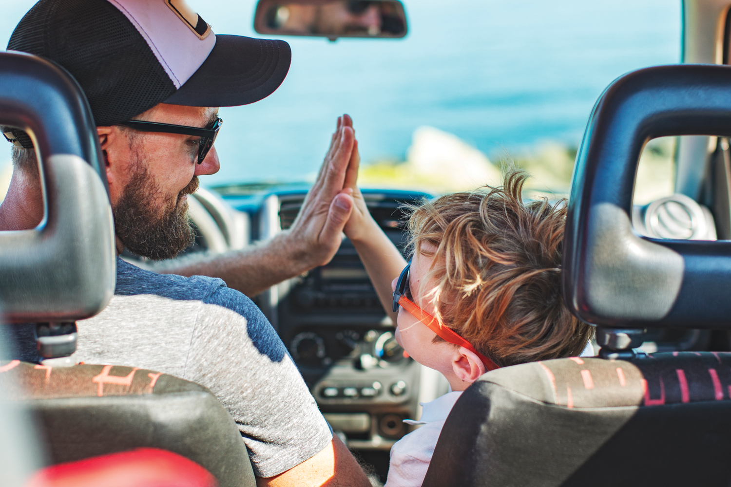 happy father and son high five in the car