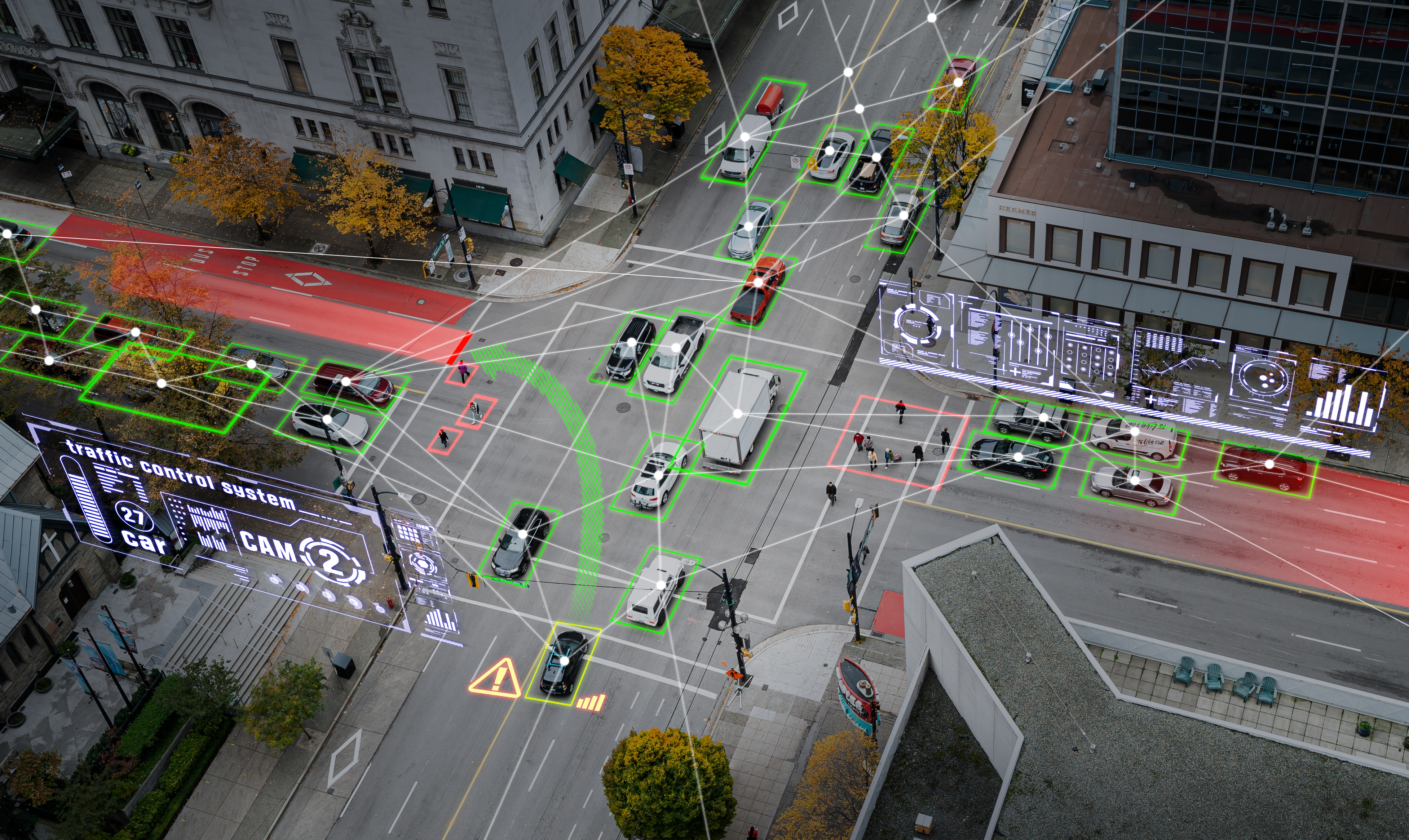 A bird's eye image of a busy crossroad, with green lines highlighting the ways vehicles can connect with their environment and each other.