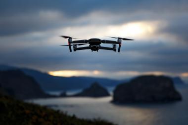 Drone flying over coastal landscape representing GNSS positioning for UAV and drone navigation applications