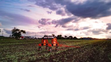 A Hural agricultural robot operates autonomously in a cultivated field at sunset. The robotic agriculture solution supports precision farming workflows that can benefit from accurate GNSS positioning and navigation technologies.
