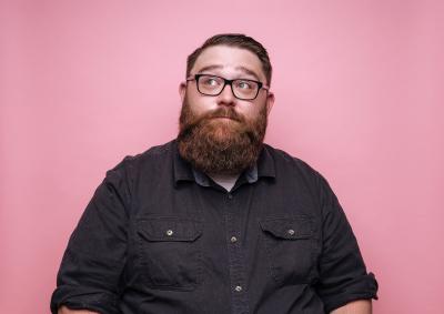 Bearded man on pink background. Looking bored to the top.