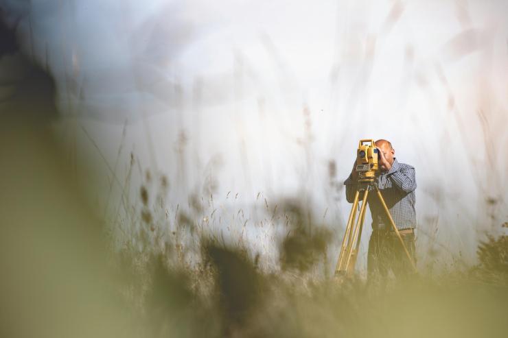 theodolite being used in a field 