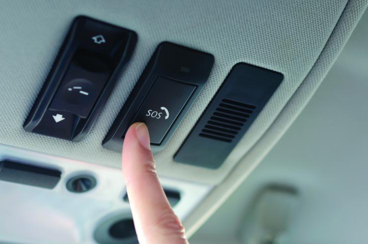 sos button in car being pressed by a finger