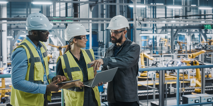 engineers discussing automotive industrial manufacturing technology on modern vehicle assembly plant
