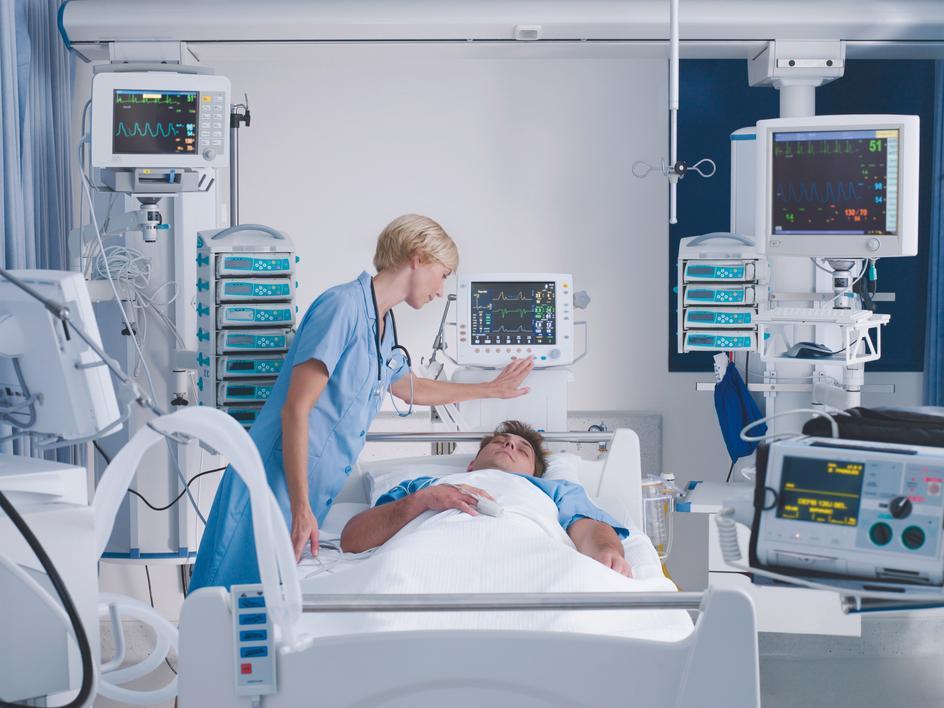 nurse in the hospital checking screen in a room full of medical equipment 