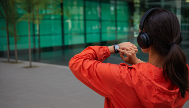 Person checking a smartwatch while outdoors, illustrating a wearable technology application